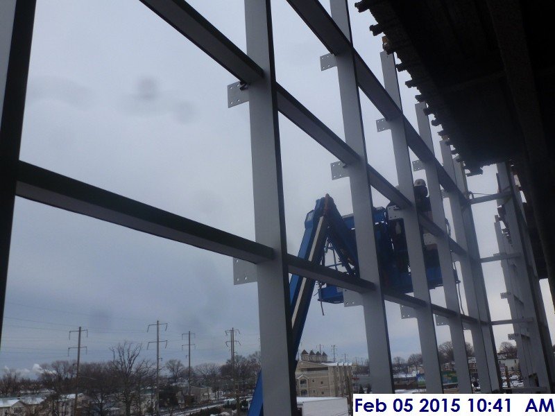 Installing weather strips along the curtain wall South Elevation